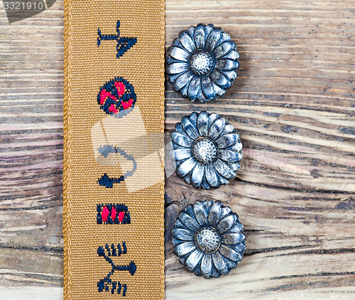 Image of vintage tape with embroidered ornaments and old buttons flowers