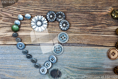 Image of antique buttons heart on old textured boards