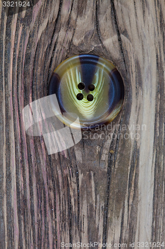 Image of vintage button on the aged textured boards