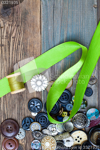 Image of set of vintage buttons with green tape and spool of thread