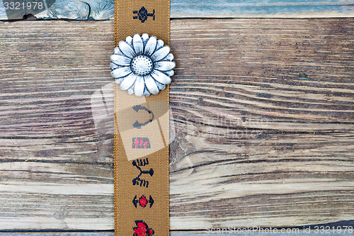 Image of vintage tape with embroidered ornaments and old flower button