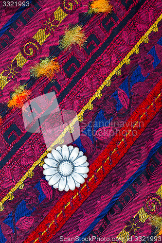 Image of vintage tape with embroidered ornaments and old button