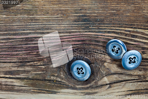 Image of vintage buttons on the aged textured boards