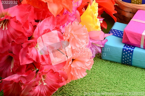 Image of present gift box and flower bouquet on silk