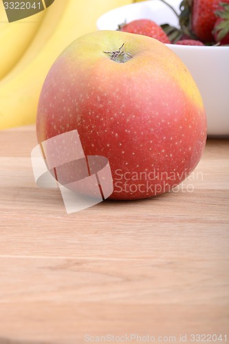 Image of Fruits. Arrangement of various fresh ripe fruits: bananas, apple and strawberries closeup