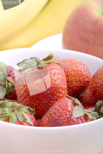 Image of Fruits. Arrangement of various fresh ripe fruits: bananas, apple and strawberries closeup