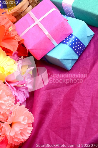 Image of present gift box and flower bouquet on silk