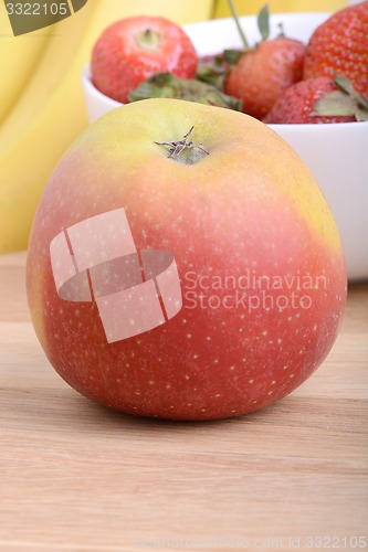 Image of Fruits. Arrangement of various fresh ripe fruits: bananas, apple and strawberries closeup