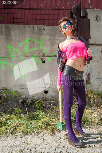 Image of Pretty girl in pink net blouse with sledge hammer