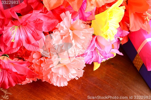 Image of present gift box and flower bouquet on silk