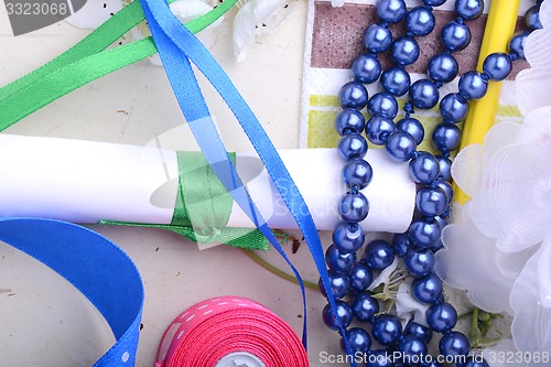 Image of Office table with flower, ribbons, pencils, pearls