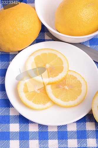 Image of Fresh juicy sliced lemon on a ceramic plate.