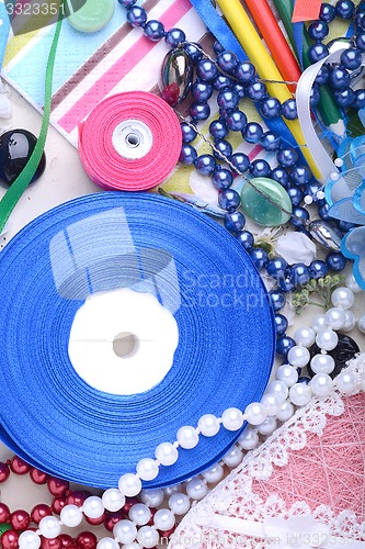 Image of Office table with flower, ribbons, pencils, pearls