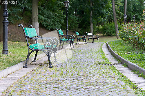 Image of Park walkway of paving stones and benches.