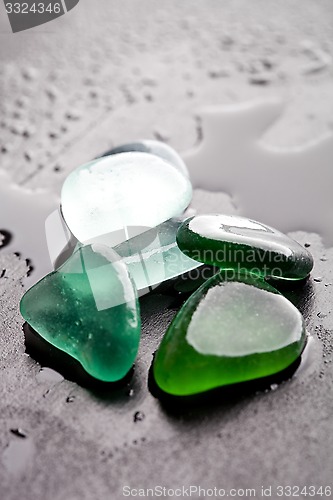 Image of wet glass pieces polished by the sea 