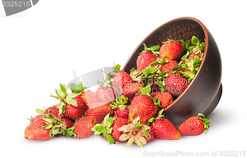 Image of Scattered ripe juicy strawberries in a ceramic bowl