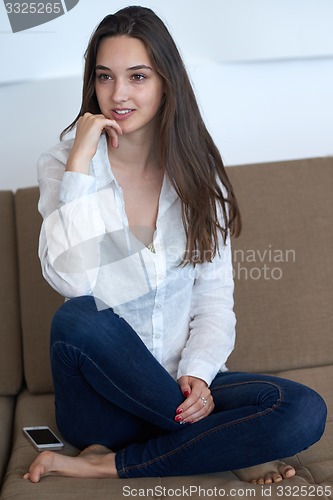Image of relaxed young woman at home working on laptop computer
