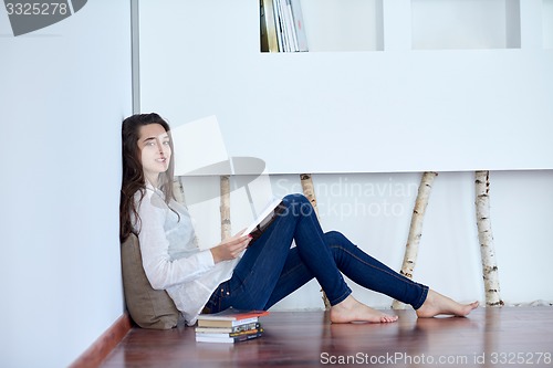 Image of relaxed young woman at home working on laptop computer