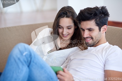 Image of couple at modern home using tablet computer