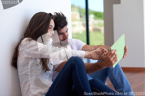 Image of couple at modern home using tablet computer