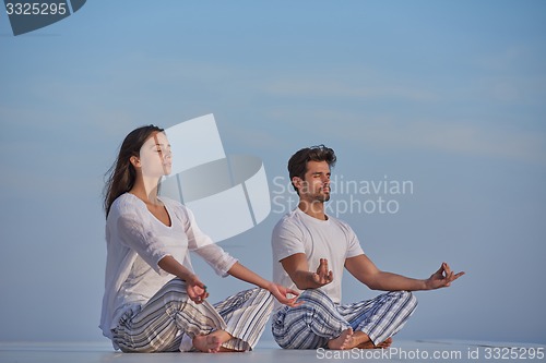 Image of young couple practicing yoga