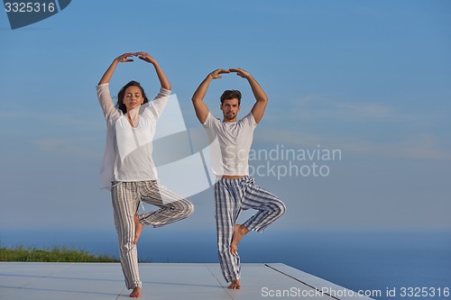 Image of young couple practicing yoga