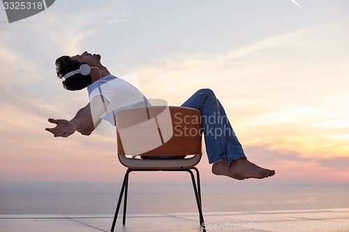 Image of relaxed young man at home on balcony