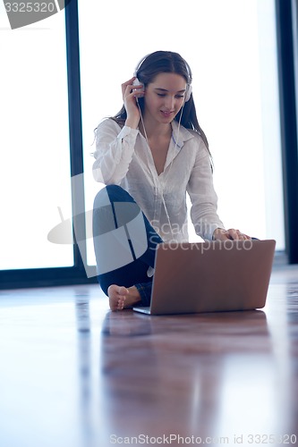 Image of relaxed young woman at home working on laptop computer