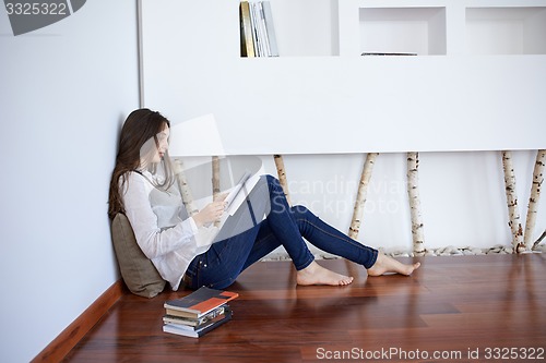 Image of relaxed young woman at home working on laptop computer