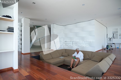 Image of Portrait of senior man relaxing in sofa