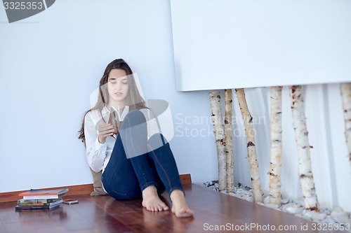 Image of relaxed young woman at home working on laptop computer