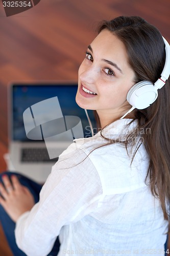 Image of relaxed young woman at home working on laptop computer