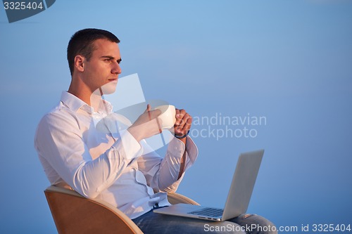 Image of relaxed young man at home on balcony