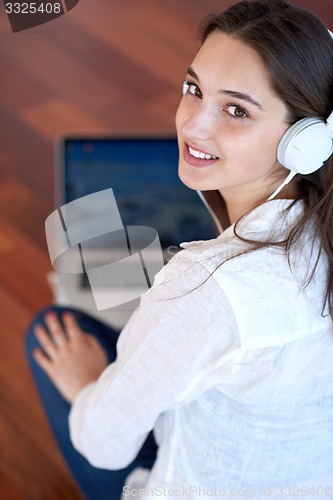Image of relaxed young woman at home working on laptop computer