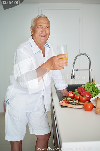 Image of man cooking at home preparing salad in kitchen