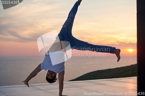 Image of relaxed young man at home on balcony