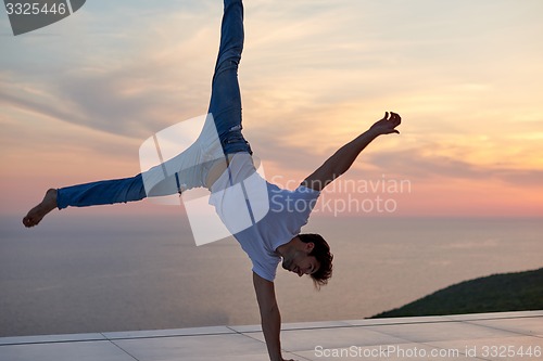 Image of relaxed young man at home on balcony