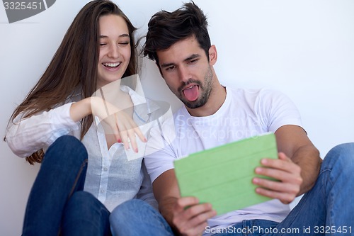 Image of couple at modern home using tablet computer