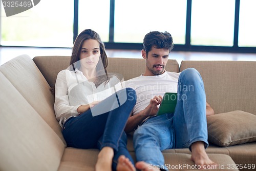 Image of couple at modern home using tablet computer