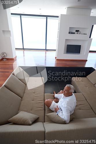 Image of Portrait of senior man relaxing in sofa