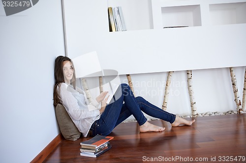Image of relaxed young woman at home working on laptop computer