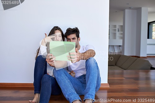 Image of couple at modern home using tablet computer