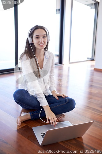Image of relaxed young woman at home working on laptop computer