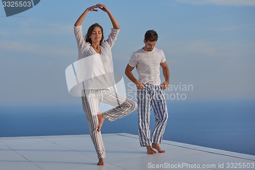 Image of young couple practicing yoga