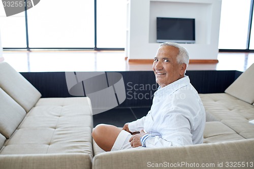 Image of Portrait of senior man relaxing in sofa