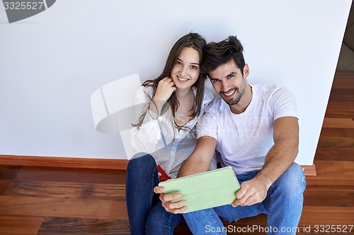 Image of couple at modern home using tablet computer