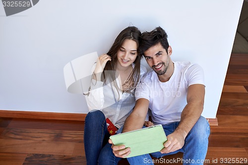 Image of couple at modern home using tablet computer