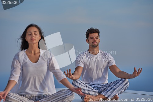 Image of young couple practicing yoga