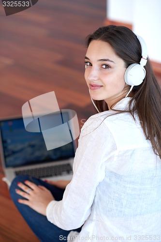 Image of relaxed young woman at home working on laptop computer