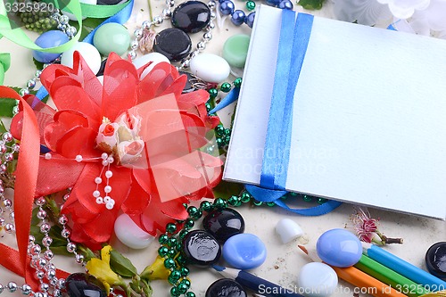 Image of Office table with flower, blank notepad and colorful pencils